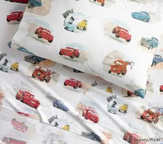 two sheets with cars printed on them are laying next to each other in the bed