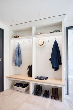a white coat rack with shoes and hats on it next to a door in a hallway