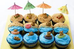 cupcakes decorated with blue frosting and teddy bears on top are arranged in rows