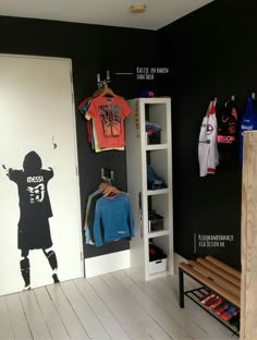 a kid's room with black walls, white floors and sports memorabilia on the wall