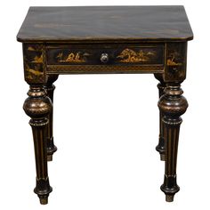 a black and gold painted table with two drawers on one side, an open drawer on the other