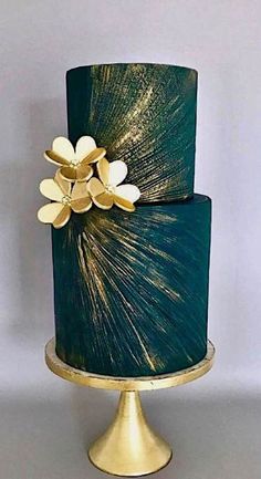 a green and gold cake with flowers on top