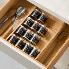 an open drawer with spoons and spices in it