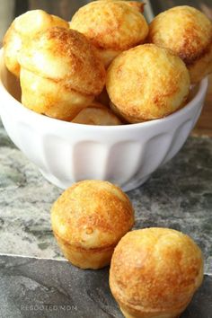 a white bowl filled with mini muffins on top of a marble countertop