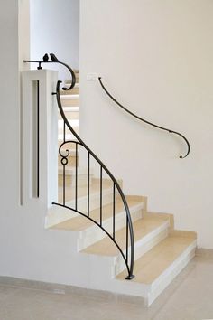 a white staircase with black railing and handrail