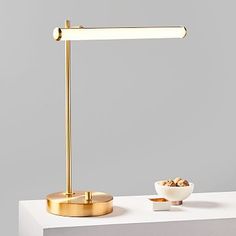 a table lamp with a bowl of nuts on it next to a white countertop