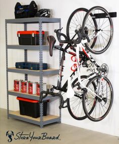 a bicycle mounted to the side of a metal shelving unit in a storage room