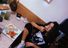 a woman sitting at a table eating food