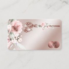 a business card with pink flowers and a monogrammed snake on the front in gold