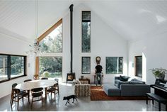 a living room filled with furniture and a fire place next to a dining table on top of a hard wood floor