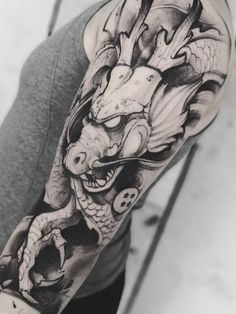 a man's arm with a dragon tattoo on the left side of his arm