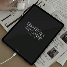 a tablet computer sitting on top of a table next to some papers and headphones