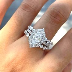 a woman's hand with a diamond ring on top of her finger and an engagement band