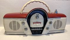 an old fashioned radio with red and white trim on it's side, sitting on a table