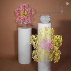 two white vases with yellow, pink and purple beads on them next to each other