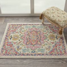 an ornate rug with a bench in front of it on the floor next to a window