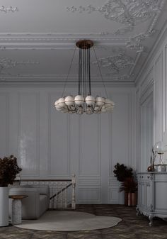 an elegant living room with white walls and wood flooring, chandelier above the couch