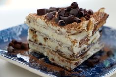 a piece of cake with chocolate chips on top is sitting on a blue and white plate