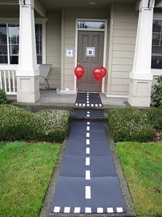 a house with a painted walkway leading to the front door and two red heart balloons