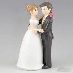 a bride and groom figurine standing next to each other