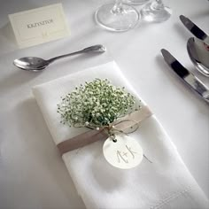 a place setting with napkins, silverware and baby's breath flower arrangement