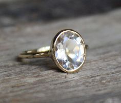 a close up of a ring on a wooden surface with a stone in the middle