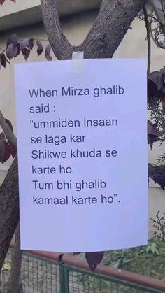 a sign posted on a tree in front of a building that says, when mizza ghajib said'ummiden insan se laga kar