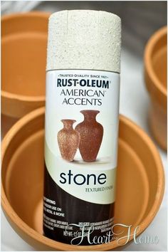 a can of stone paint sitting in front of three clay pots