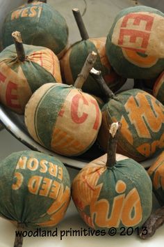 a bowl filled with orange and green painted pumpkins sitting on top of a table