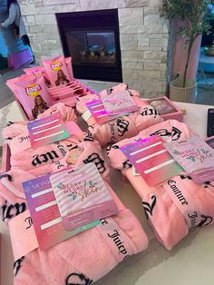 pink towels are laid out on a table in front of a fire place and fireplace