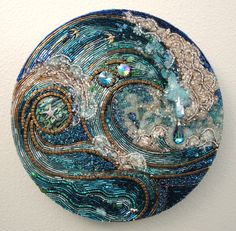 a circular piece of art made out of glass and beaded with beads on it