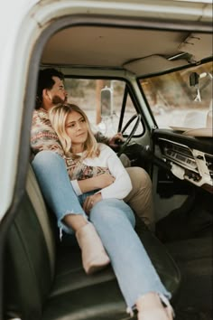 a man and woman sitting in the back seat of a truck