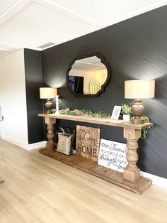 a living room with black walls and white trim on the wall, wood flooring