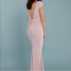 a woman in a long pink dress is looking back