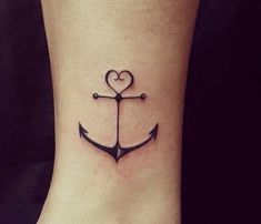 a small anchor with a heart tattoo on the side of its foot is shown in black ink