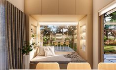 a room with a bed, table and chairs next to a window that looks out onto the yard