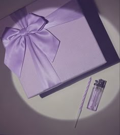 an open purple gift box next to a candle