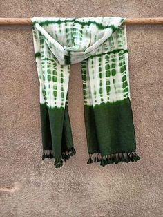 a green and white scarf hanging on a wall