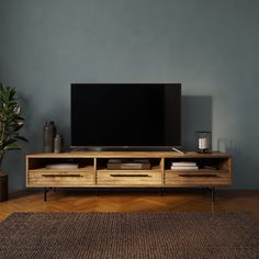 an entertainment center with a flat screen tv on it's stand in front of a blue wall