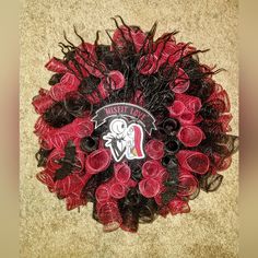 a red and black wreath on the floor with an oakland football team logo painted on it