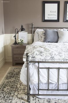 a bedroom with a bed, nightstands and pictures hanging on the wall above it