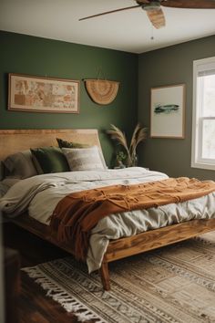 a bed sitting in a bedroom next to a window with a fan on top of it