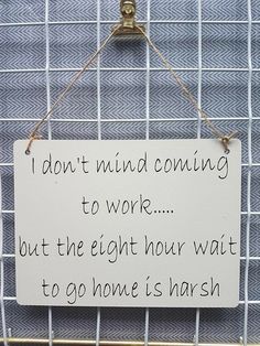 a sign hanging on the side of a fence that says i don't mind coming to work but the eight hour wait to go home is harsh