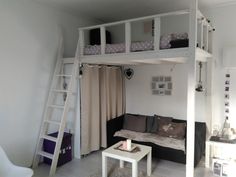 a loft bed with a couch underneath it and a ladder to the upper level above