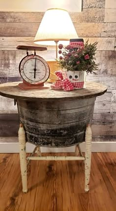 an old barrel turned into a table with a clock on top and flowers in the middle