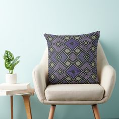 a chair with a pillow on it in front of a blue wall and a potted plant