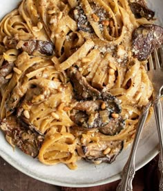 a white plate topped with pasta and mushrooms