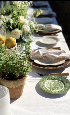 an image of a table setting with plates and flowers in the center, including lemons