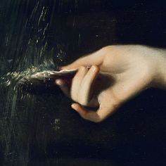 a close up of a person's hand holding something in their left hand on a black surface