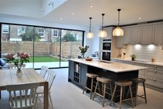 an open kitchen and dining room with sliding glass doors leading to the back yard area